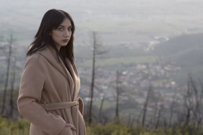 Ragazza che indossa un cappotto beige e ha l'aria triste